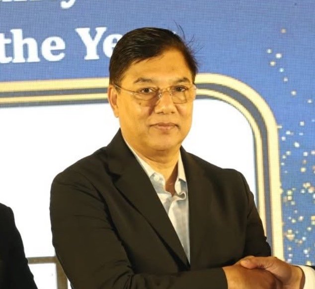 M. Rashiduzzaman Millat seated in a dark suit at an event